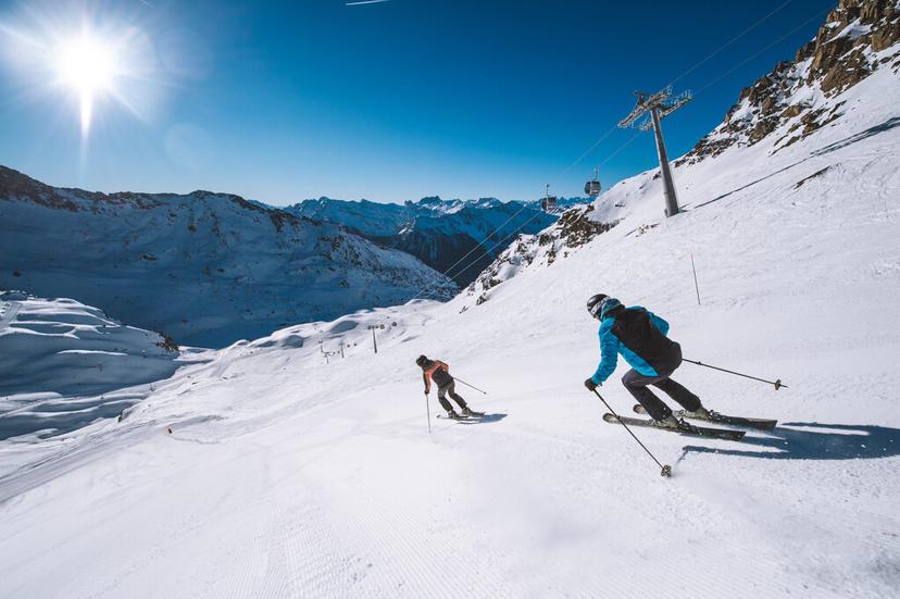 Skiers enjoying wide open ski slope in French Alps